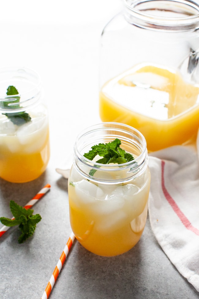 orange mint tea in a mason jar with straws