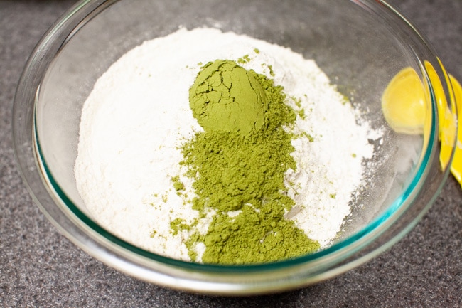 Matcha powder added to flour and salt in glass bowl for Matcha Cookies from thelittlekiitchen.com