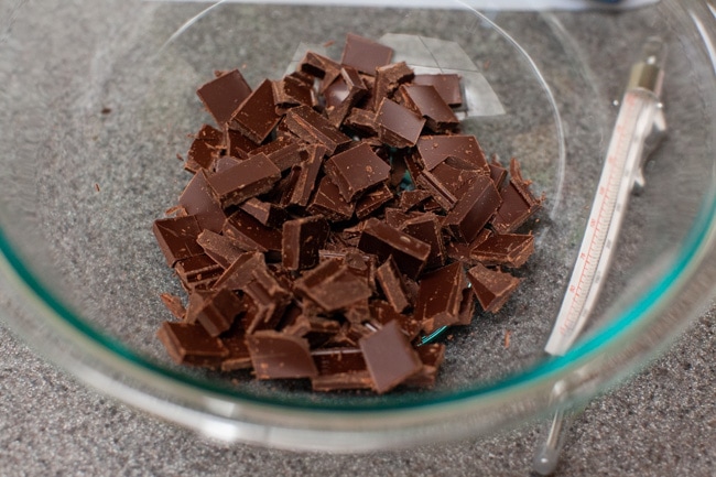 Glass bowl filled with roughly chopped chocolate pieces from thelittlekiitchen.com
